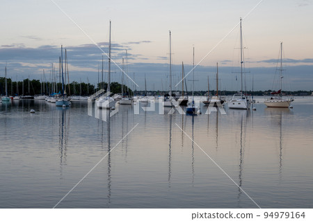 Sailboats in Dinner Key anchorage reflected in calm water of Biscayne Bay. 94979164