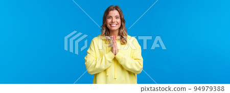 Cheerful young european female practice yoga, greeting sensei with namaste gesture, hold hands in pray and smiling grateful with relaxed carefree expression, smiling camera, blue background 94979388