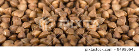 Texture of buckwheat. Background for dry buckwheat design. Large size for banner printing or packaging. Top view of evenly scattered buckwheat groats. Texture of buckwheat. Background for dry buckwheat design. Large size for banner printing or packaging. Top view of evenly scattered buckwheat groats. 94980643