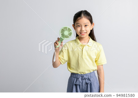 Korean young girl wearing gym clothes in white background studio__holding handheld portable fan 94981580