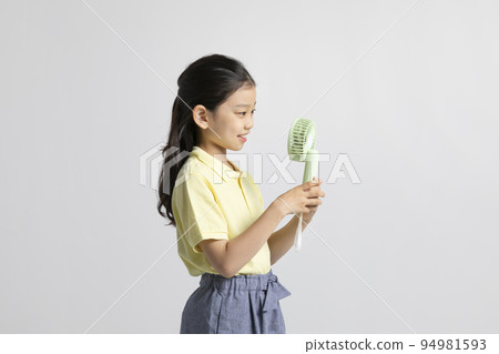 Korean young girl wearing gym clothes in white background studio__holding handheld portable fan Korean young girl wearing gym clothes in white background studio__holding handheld portable fan 94981593