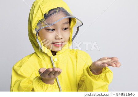 cute young Korean girl, rainy season concept in white background studio__stretching out her hand in a raincoat cute young Korean girl, rainy season concept in white background studio__stretching out her hand in a raincoat 94981640