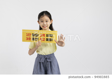 Korean young girl wearing gym clothes in white background studio__holding a drive safe copyspace panel with stop hand motion Korean young girl wearing gym clothes in white background studio__holding a drive safe copyspace panel with stop hand motion 94981665