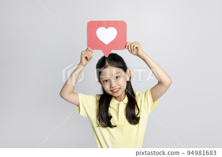 Korean young girl wearing gym clothes in white background studio__holding a heart shape copyspace panel Korean young girl wearing gym clothes in white background studio__holding a heart shape copyspace panel 94981683