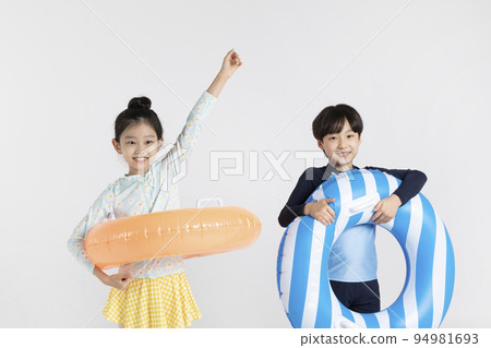 Korean boy and girl, summer concept in white background_holding a inflatable pool float Korean boy and girl, summer concept in white background_holding a inflatable pool float 94981693