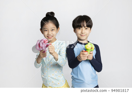 Korean boy and girl, summer concept in white background_holding a water gun Korean boy and girl, summer concept in white background_holding a water gun 94981817