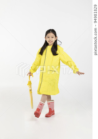 cute young Korean girl, rainy season concept in white background studio__wearing raincoat and holding umbrella 94981829