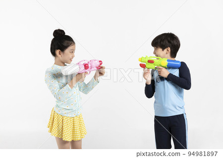 Korean boy and girl, summer concept in white background_holding a water gun 94981897