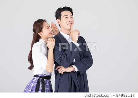 Korean young couple, man and woman wearing modern Hanbok_whispering to each other 94982117