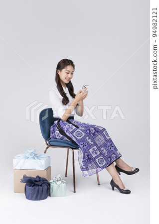 beautiful Korean woman in 20s wearing modern Hanbok_searching smartphone beautiful Korean woman in 20s wearing modern Hanbok_searching smartphone 94982121