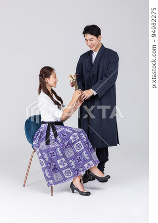 Korean young couple, man and woman wearing modern Hanbok_giving bunch of flower 94982275