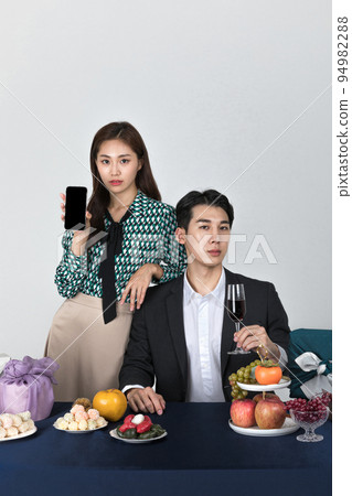 Korean young couple, man and woman wearing modern Hanbok_holding smartphone Korean young couple, man and woman wearing modern Hanbok_holding smartphone 94982288