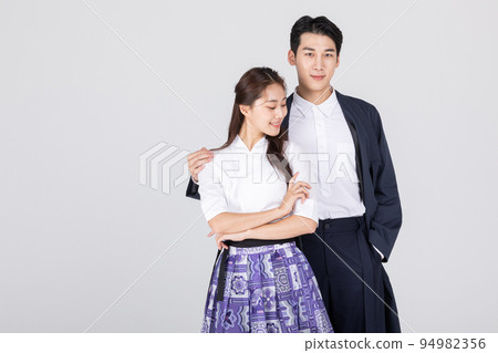 Korean young couple, man and woman wearing modern Hanbok_putting arms around each other's shoulders 94982356