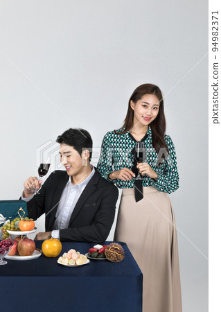Korean young couple, man and woman wearing modern Hanbok_holding a wine glass 94982371
