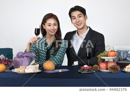Korean young couple, man and woman wearing modern Hanbok_holding a wine glass Korean young couple, man and woman wearing modern Hanbok_holding a wine glass 94982376