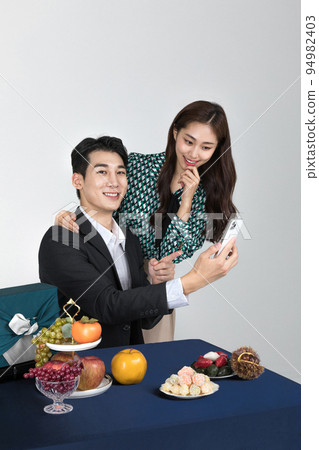 Korean young couple, man and woman wearing modern Hanbok_watching smartphone 94982403