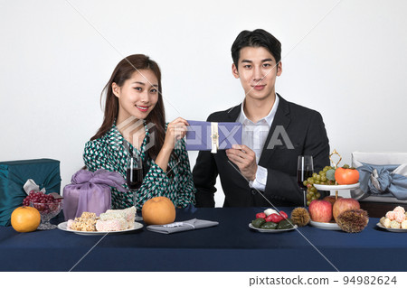 Korean young couple, man and woman wearing modern Hanbok_holding Korean traditional wedding clutch, envelope Korean young couple, man and woman wearing modern Hanbok_holding Korean traditional wedding clutch, envelope 94982624