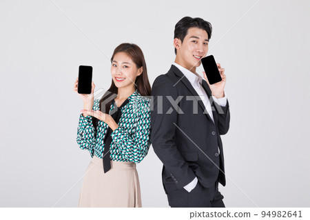 Korean young couple, man and woman wearing modern Hanbok_holding smartphone 94982641