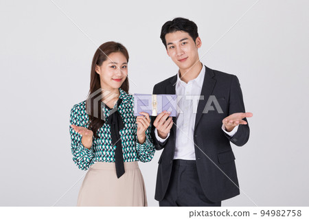 Korean young couple, man and woman wearing modern Hanbok_holding Korean traditional wedding clutch, envelope Korean young couple, man and woman wearing modern Hanbok_holding Korean traditional wedding clutch, envelope 94982758