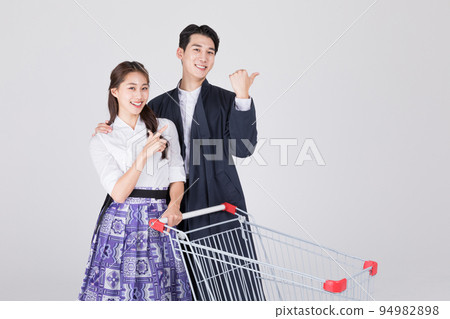 Korean couple_young man and woman in 20s_wearing modern Hanbok_with shopping cart 94982898
