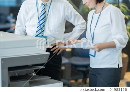 Men and women standing and talking with printed documents 94983136