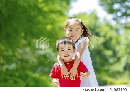 Sister and brother playing in the park in early summer 94983193