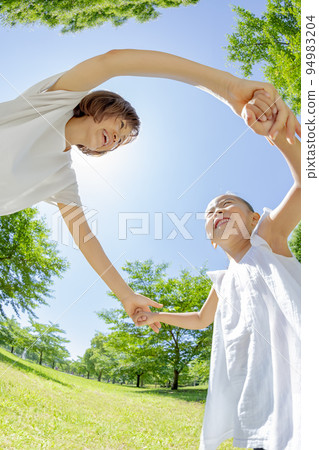 Mother and daughter playing in the early summer park Mother and daughter playing in the early summer park 94983204