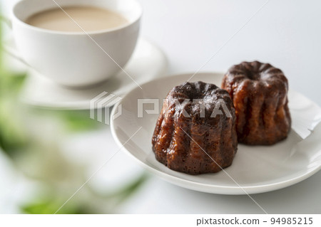 French pastry canelé and caffe latte on a white plate [white background] 94985215