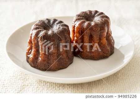 白盤上的法式糕點 canelé 白盤上的法式糕點 canelé 94985226