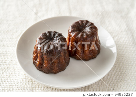 白盤上的法式糕點 canelé 白盤上的法式糕點 canelé 94985227