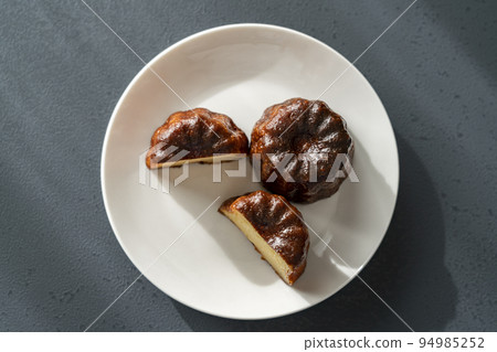 白盤上的法式糕點 canelé [黑色背景] 94985252