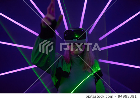 Woman is using virtual reality headset to access in metaverse. 94985381