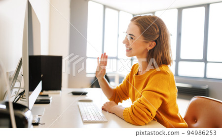 Happy young female having video call while working remotely or studying online on computer from home Happy young female having video call while working remotely or studying online on computer from home 94986253