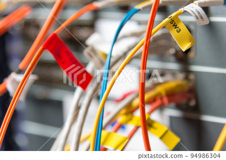 detail of server rack with fiber optic cables attached to front panel switch ports detail of server rack with fiber optic cables attached to front panel switch ports 94986304