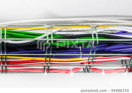 Ethernet cables in a cable guard leading along the ceiling inside server room 94986350