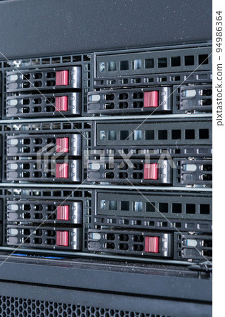 Row of hard drives serving as data storage inside server room 94986364