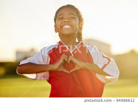 Girl is happy after football, shows love with a heart hand and smiling at support. Portrait of young athlete celebrate team sports win in gear on the field, excited about exercise and fitness. 94986612