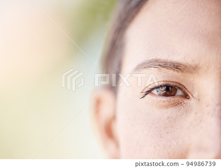 Face portrait of a woman eye thinking with mockup or blurred background with bokeh. Head of a serious or focus young female with light freckle skin, staring with brown eyes outdoors in nature Face portrait of a woman eye thinking with mockup or blurred background with bokeh. Head of a serious or focus young female with light freckle skin, staring with brown eyes outdoors in nature 94986739