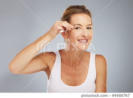 Happy senior woman, correct eyebrow hair on face with tweezers and cosmetic in studio gray background. Microblading makeup in beauty, natural cosmetics with tool and clean skincare portrait 94986767
