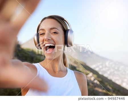 Fitness, headphone music and selfie woman enjoying peaceful mountain workout rest for wellbeing. Wellness girl happy, excited and cheerful photograph break in nature landscape to relax mind. Fitness, headphone music and selfie woman enjoying peaceful mountain workout rest for wellbeing. Wellness girl happy, excited and cheerful photograph break in nature landscape to relax mind. 94987446