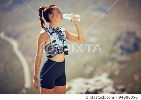 Fitness, runner and woman drinking water after running, training and cardio exercise outdoors in summer. Healthy, sports and thirsty athlete enjoying a bottle of liquid after workout in the sun Fitness, runner and woman drinking water after running, training and cardio exercise outdoors in summer. Healthy, sports and thirsty athlete enjoying a bottle of liquid after workout in the sun 94988050
