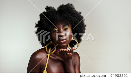 Black woman fashion model blow kiss for beauty, makeup and African empowerment in skincare and afro hair. Headshot portrait of creative young Nigeria girl or happy black person in studio background 94988261