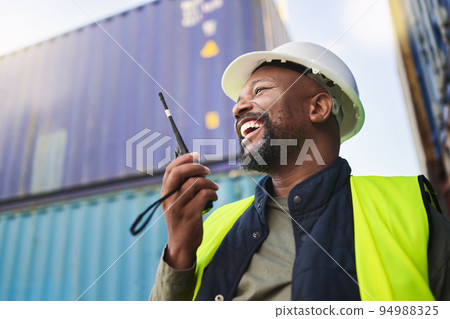 Logistics, supply chain and radio with a man delivery worker talking on a walkie talkie while working in a container yard. Ecommerce, stock and cargo in the retail, shipping and export industry 94988325
