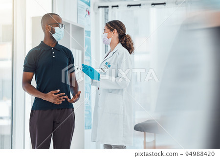 Covid, mask and doctor, woman consulting patient for corona virus vaccine and treatment. Health check, healthcare and female medical professional helping, talking or conversation in hospital clinic. 94988420