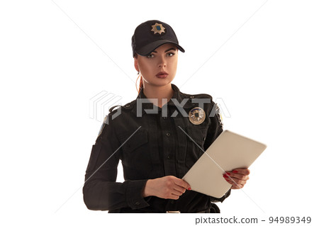 Close-up shot of a redheaded female police officer posing for the camera isolated on white background. 94989349