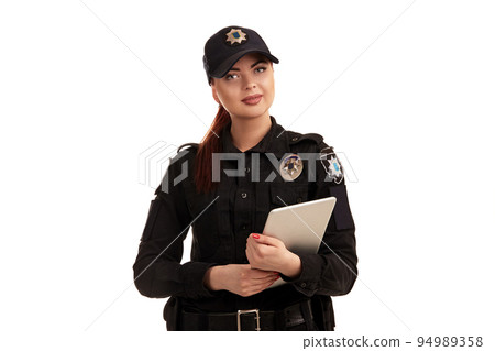 Close-up shot of a redheaded female police officer posing for the camera isolated on white background. 94989358