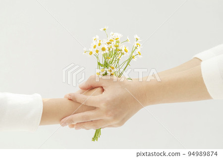 Daughter and mother's hand giving a bouquet 94989874