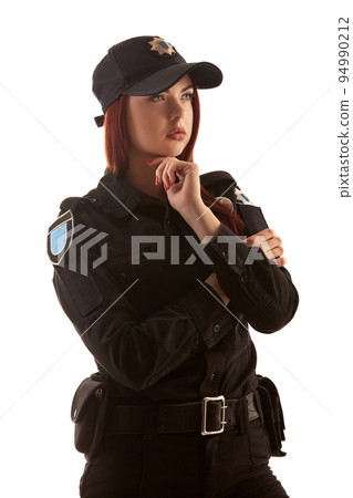 Redheaded female police officer is posing for the camera isolated on white background. 94990212