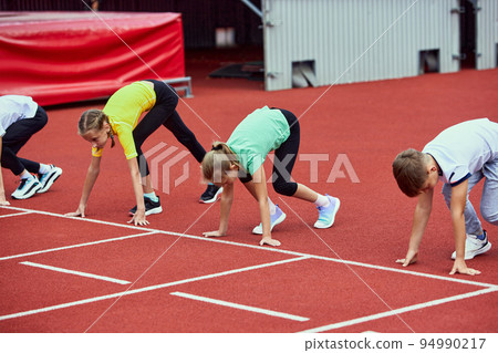 Start. Group of kids getting ready to run on treadmill at the stadium or arena. Little boys, girls in sportswear training as athletes outdoor. Concept of sport, achievements, studying, skills 94990217