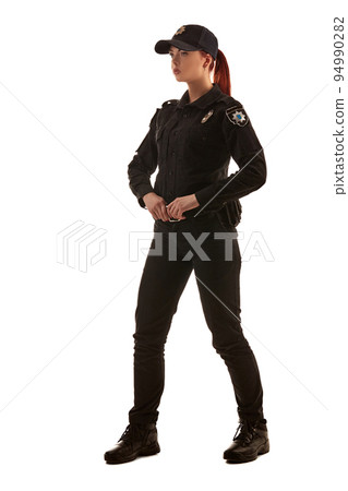 Full length shot of a redheaded female police officer posing for the camera isolated on white background. Full length shot of a redheaded female police officer posing for the camera isolated on white background. 94990282